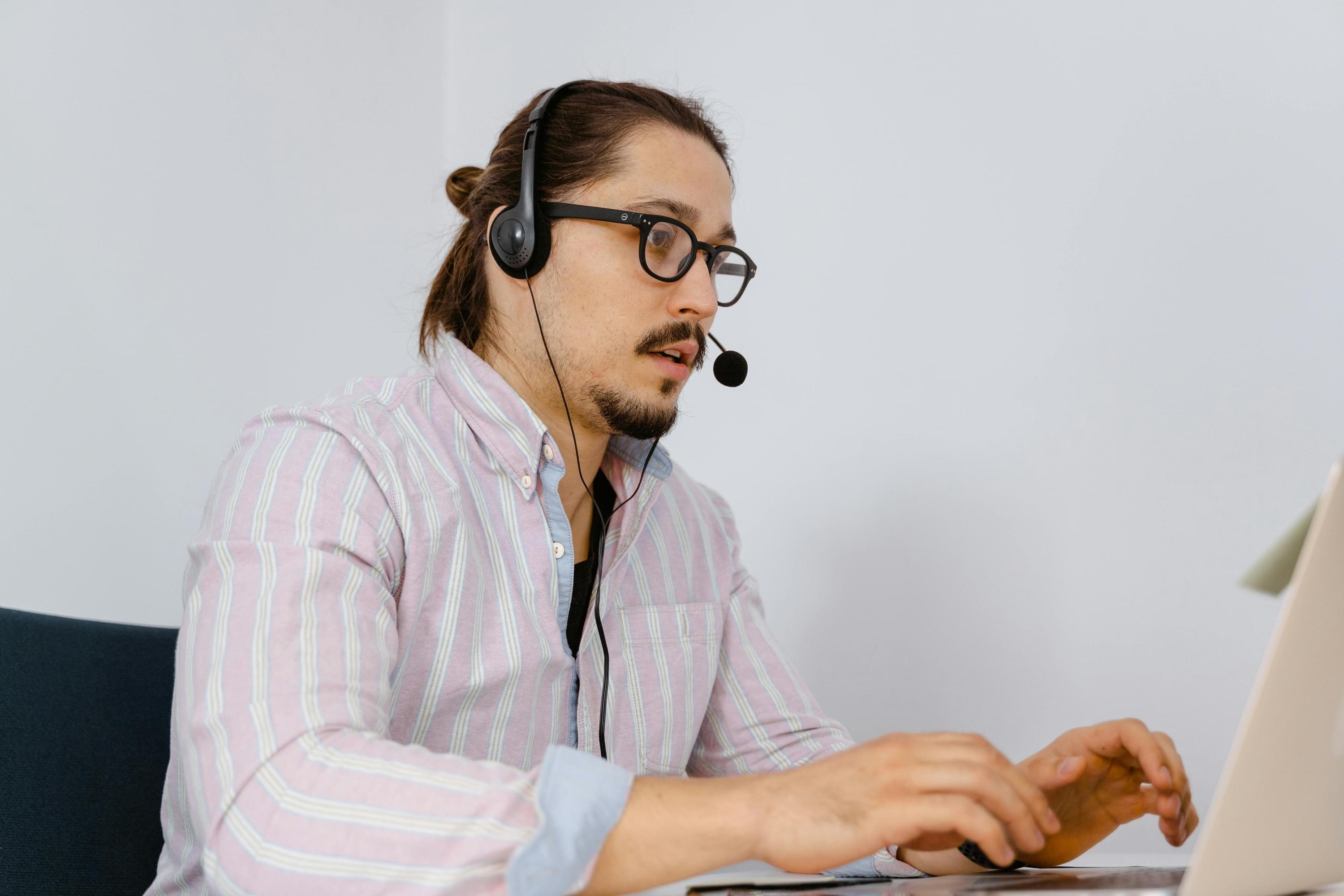 Mann mit Headset im Videocall, konzentriert vor Laptop – Symbol für digitales  Verkaufstraining, Remote Closing und ortsunabhängige Vertriebsarbeit.