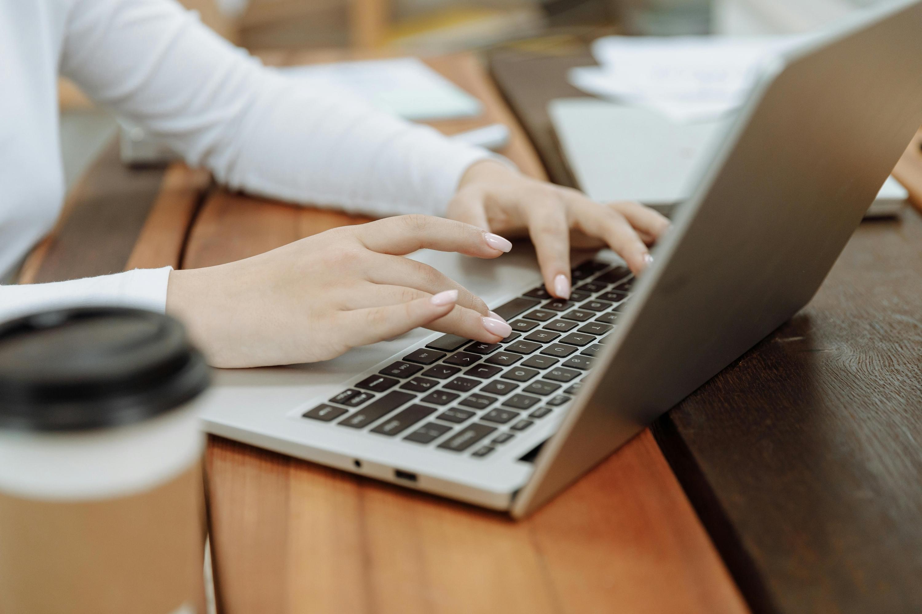 Nahaufnahme von Händen auf Laptop-Tastatur – Symbol für digitales Arbeiten,  Flexibilität und ortsunabhängigen Vertrieb.